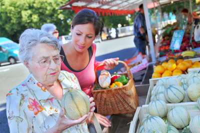 Young woman helping elderly woman with grocery shopping