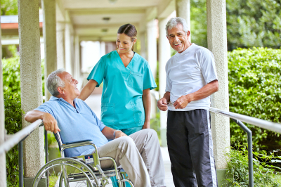 Two happy senior people taking to a nurse in a nursing home